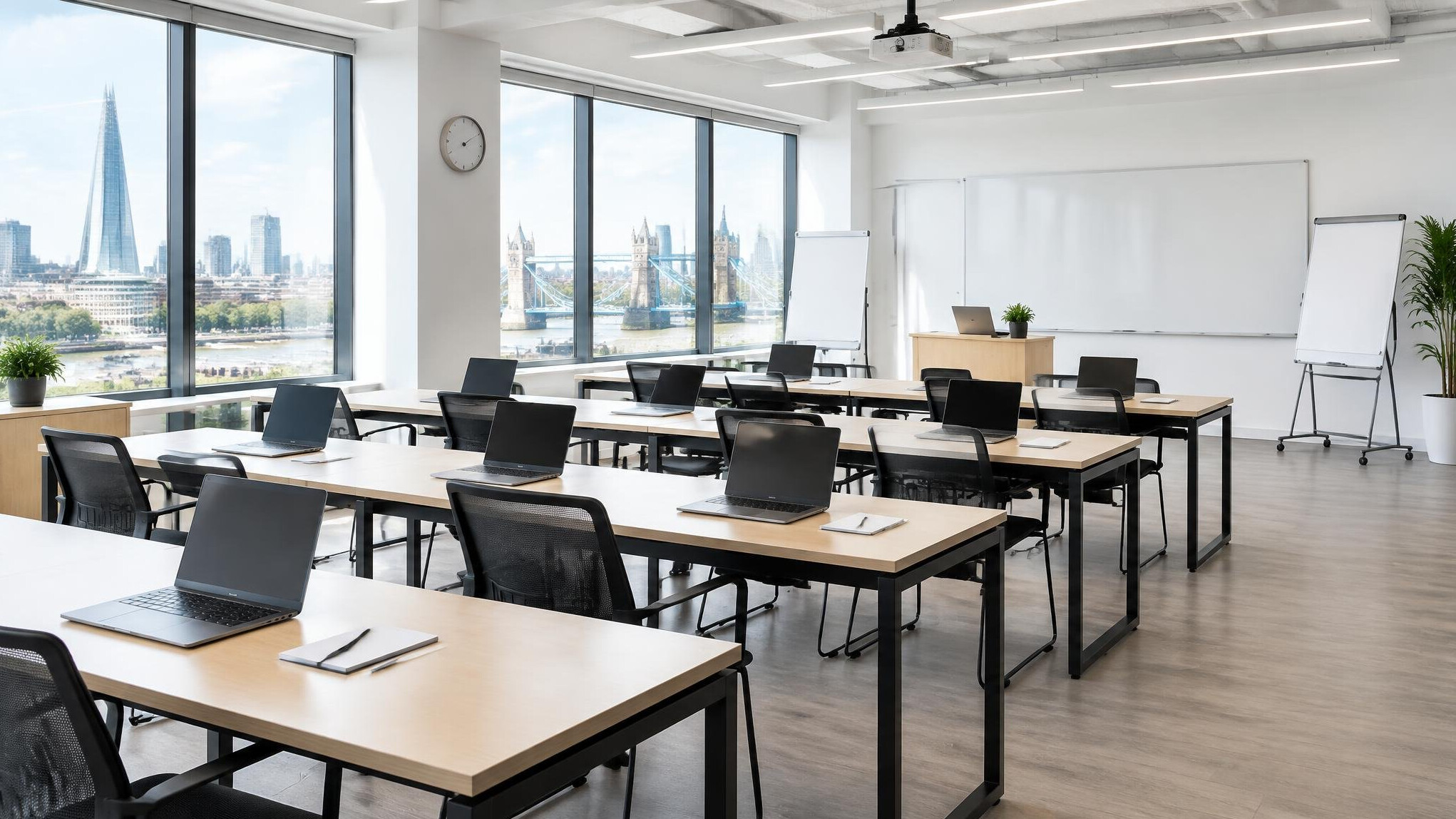 Modern open-plan training studio with empty desks and laptops